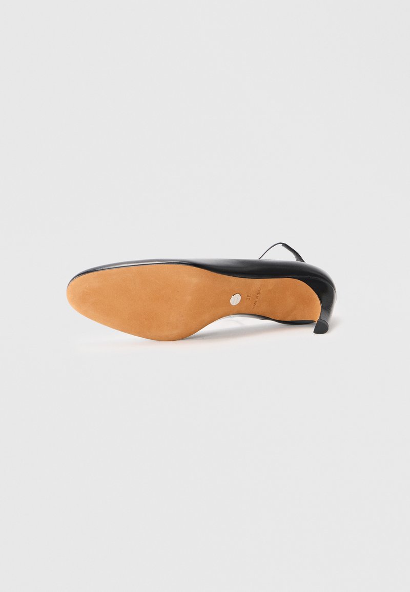 Schwarzer Lederstiefel mit hohen Absätzen und spitz zulaufender Zehenpartie, elegantem Design, einer hellbraunen Gummisohle und einem dünnen Absatz. Glatte Textur, minimale Akzente.