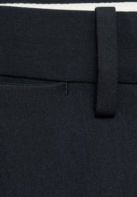 Svarta denimshorts med en mjuk textur, dubbelsydda sömmar och en vävd vit rand längs midjebandet.