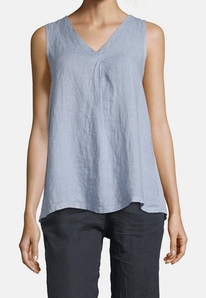 Haut sans manches en lin bleu clair avec un col en V, porté avec un pantalon ample foncé, présenté sur une personne des épaules aux hanches.