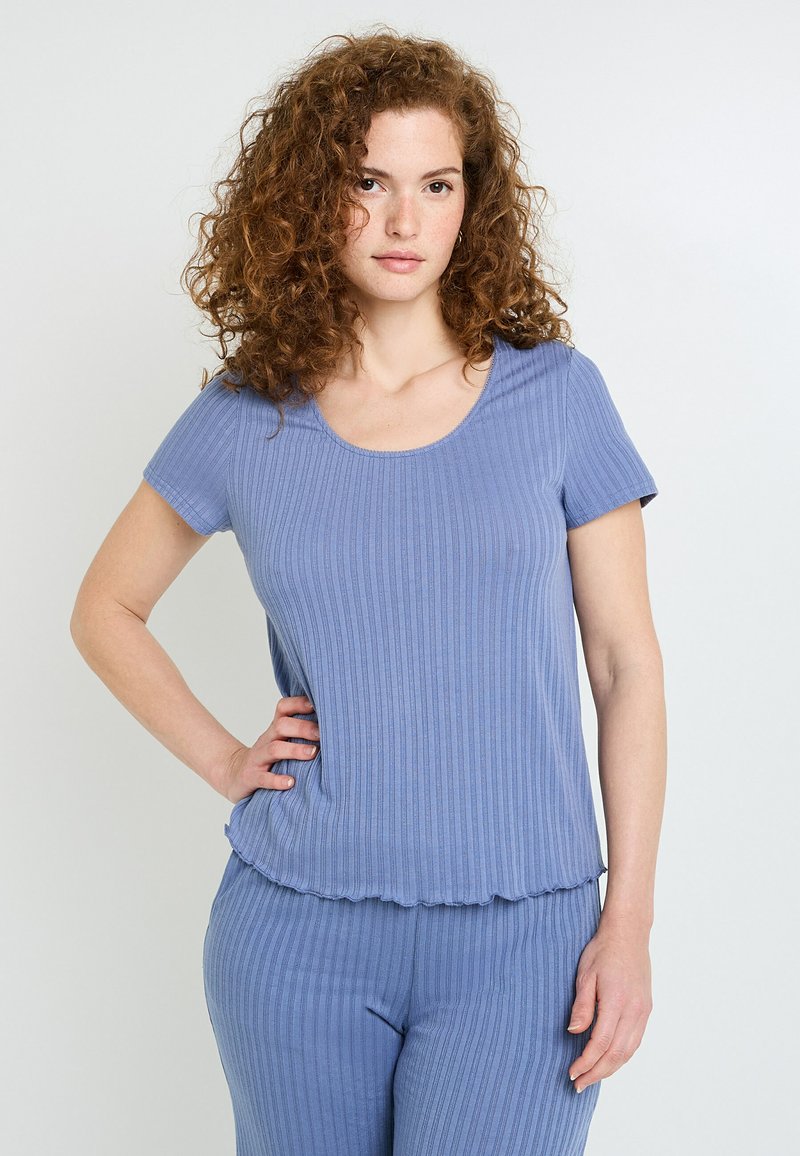 Haut à manches courtes côtelé bleu clair avec un col rond et un ourlet ondulé, associé à un pantalon côtelé assorti. Texture de tissu douce.