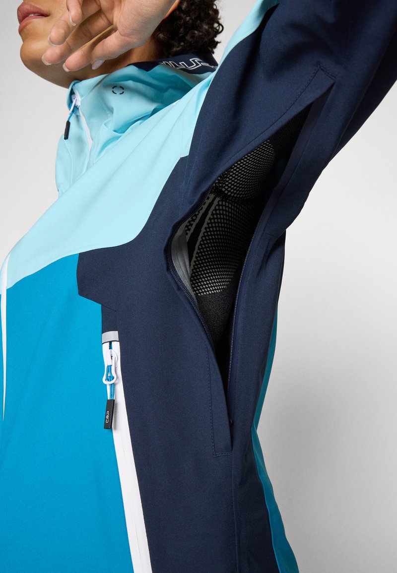 Blau und marineblaue wasserdichte Jacke mit einem Netzunterarmbelüftung, Reißverschlusstaschen und reflektierenden Akzenten. Glatte Textur, athletische Passform.