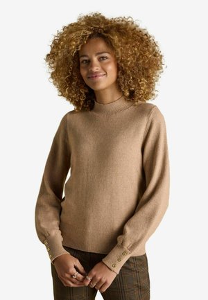 Beiger Strickpullover mit hohem Kragen und gerippten Manschetten. Verfügt über drei goldene Knöpfe an den Manschetten, hat eine weiche Textur, eine lockere Passform und lange Ärmel.