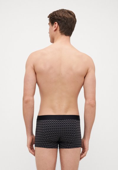 Black patterned boxer shorts with a fitted design and elastic waistband, featuring a geometric zigzag pattern throughout.