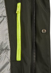 Svart jacka med en grön dragkedjeficka och en texturerad innerfoder. Synlig sömnad och en metallisk tryckknapp som accent.