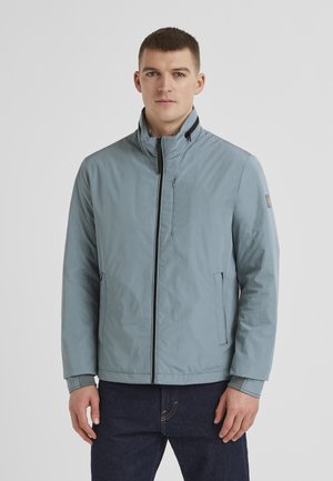 Himmelblaue, wasserdichte Jacke mit Stehkragen, Reißverschluss vorne, seitlichen Taschen und elastischen Bündchen. Glatte Textur mit minimalen Hardware-Akzenten.