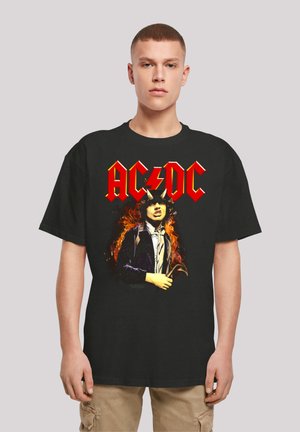Schwarzes Baumwoll-T-Shirt mit einem Grafikdruck eines männlichen Figures mit Hörnern und Flammen, überlagert mit dem Schriftzug "AC/DC" in fetten roten Buchstaben.