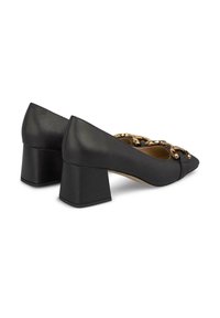Scarpe con tacco blocco in pelle nera, dalla punta appuntita e dettaglio in catena dorata sulla tomaia, con una texture liscia e un design strutturato.