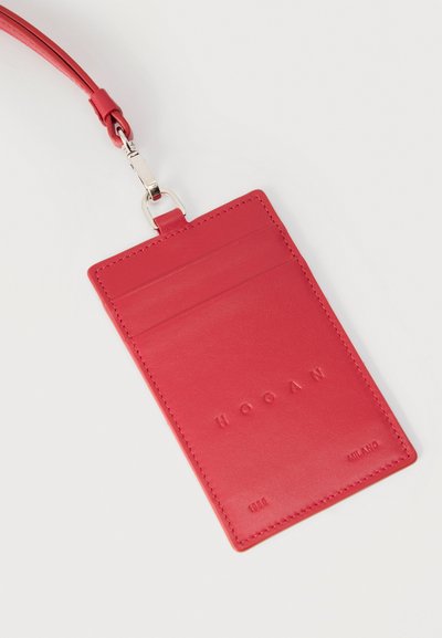 Κόκκινο δερμάτινο πορτοφόλι καρτών με ανάγλυφο λογότυπο «HOGAN», κρεμαστή θηλιά και δύο θήκες για κάρτες σε λευκό φόντο.