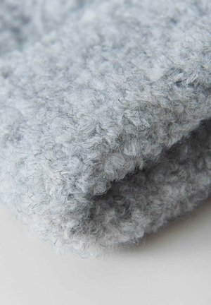 Soft gray knitted fabric featuring a textured, looped pattern. The material appears fuzzy with a slightly irregular surface.