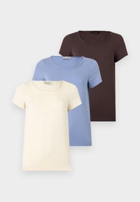 Τρία απλά κοντομάνικα t-shirts με στρογγυλή λαιμόκοψη σε εκρού, ανοιχτό μπλε και σκούρο καφέ, στοιβαγμένα το ένα πάνω στο άλλο σε ανοιχτό φόντο.