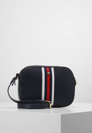 Sac bandoulière bleu marine en cuir texturé, rayures verticales rouges, blanches et bleues, emblème étoile dorée et sangle réglable avec boucle.