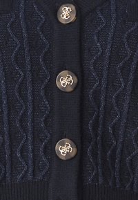 Marineblauer Strickcardigan mit wellenförmigem Muster, geripptem Stoff und runden Knöpfen mit metallischem Logoakzent.