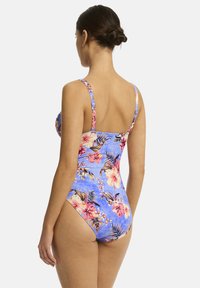 Bloemige badpak in blauw, met heldere roze bloemen en groene bladeren. Verstelbare bandjes en een gematigd rugontwerp.