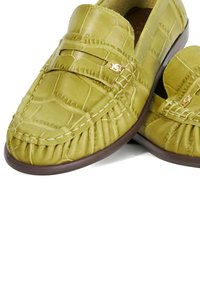 Green leather loafers with a crocodile texture, stitched detail, gold logo accent, and a brown rubber sole. Classic slip-on design.