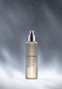 Klar glass sprayflaske med en sølvdyse. Etiketten leser "Pro-Collagen Toning Mist" i en moderne skrift. Myk tåke bakgrunnseffekt.