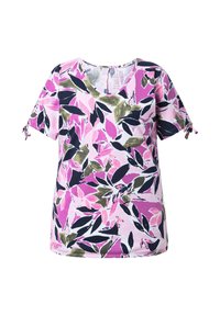 T-shirt à manches courtes et col en V avec un motif floral abstrait rose, vert olive et noir, détails de manches nouées sur fond blanc.