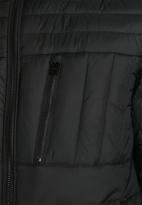 Czarna kurtka puchowa o prążkowanej fakturze, wyposażona w pionową kieszeń na zamek oraz pełny zamek błyskawiczny z przodu. Wykonana z lekkiego, wodoodpornego materiału.