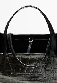 Borsa tote in pelle nera con una trama testurizzata a coccodrillo, dotata di manici lisci e un ampio interno con una chiusura sicura.