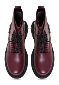 Bocanci din piele burgundy la gleznă, cu șirete negre, accente din metal argintiu și o talpă din cauciuc texturată cu un model robust.