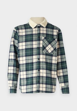 Camisa de cuadros en verde oscuro y crema con un suave cuello de forro polar. Presenta un cierre de botón y un bolsillo en el pecho con un patrón diagonal.