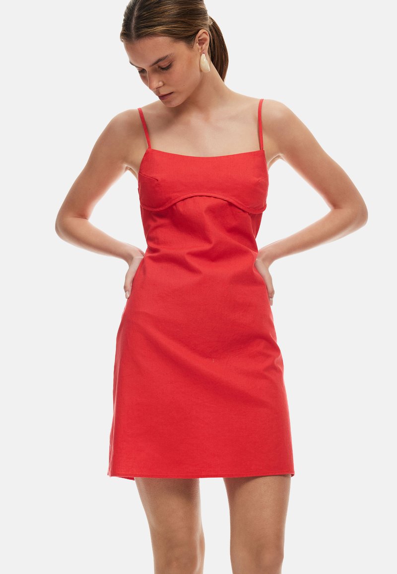 Rode linnen mini-jurk met een sweetheart halslijn, dunne verstelbare spaghettibandjes en een aangesloten silhouet. Heeft een gladde textuur en geen patronen.