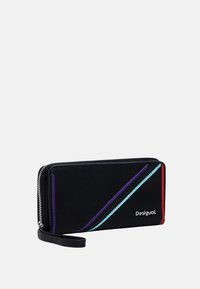 Black wallet with diagonal colored stitching in purple, blue, and red. Features a zip closure and a detachable strap. Brand name "Desigual."