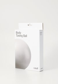 Η συσκευασία της μπάλας τόνωσης σώματος διαθέτει έναν μεγάλο, λείο ασημένιο κύκλο σε ένα λευκό κουτί. Το κείμενο περιλαμβάνει το όνομα της μάρκας "casall" και λεπτομέρειες για το προϊόν.