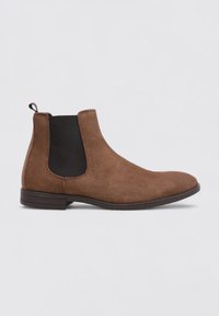 Bota Chelsea de ante marrón con diseño liso, paneles laterales elásticos negros y una lengüeta para tirar. Suela de goma de perfil bajo.