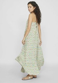 Vestido maxi de tejido ligero, con un diseño estampado en verde, azul y beige, con tirantes delgados y una silueta fluida.