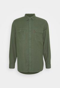 Camicia verde a maniche lunghe con bottoni, realizzata in tessuto morbido. Presenta due tasche sul petto e un colletto classico. Logo Levi's sulla tasca sinistra.