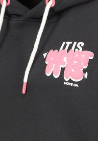 Dunkelgrauer Hoodie mit weißen Kordeln und pinken Spitzen sowie einem grafischen Druck in Pink und Weiß mit der Aufschrift "ES IST WAS ES IST."