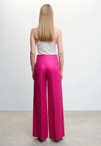 Fuksjowe spodnie o szerokich nogawkach wykonane z teksturowanej tkaniny, z wysokim stanem i gładką, elegancką sylwetką. Widok z tyłu, bez widocznych zapięć.