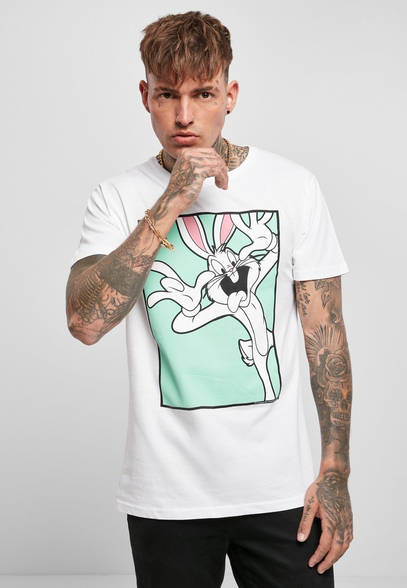 T-shirt bianco a maniche corte con grafica di un personaggio dei cartoni animati, su uno sfondo verde menta e contorni neri audaci.