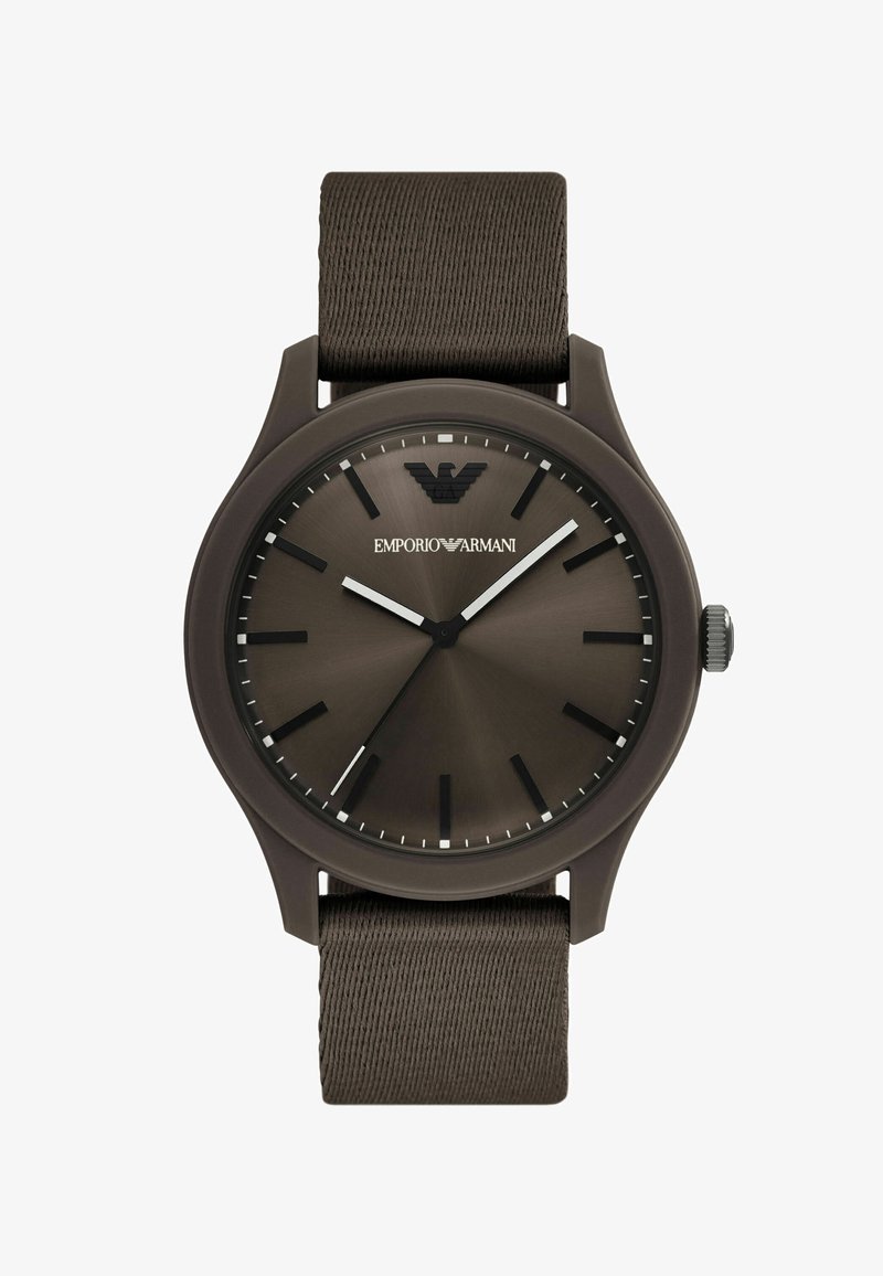 Montre avec bracelet en tissu brun et boîtier rond marron foncé. Le cadran présente un effet soleil, des accents argentés et un logo en haut.