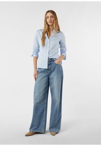 Light blue striped button-up shirt with a fitted waist, paired with wide-legged blue denim jeans. Soft texture and casual fit.