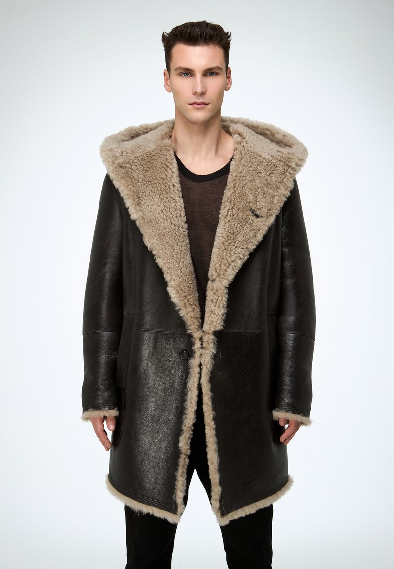 Schwarzer Ledermantel mit großem hellbraunem Lammfellkragen und Futter, mit doppelreihigem Design und zwei vorderen Taschen.