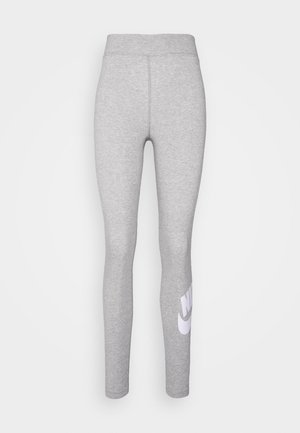 Leggings sportivi grigi con vita alta, texture liscia e un grande logo bianco della Nike sulla parte bassa della gamba sinistra.