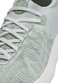 Light green sneaker featuring a textured knit upper, white laces, and a flexible sole. Includes a rubber logo accent on the tongue.