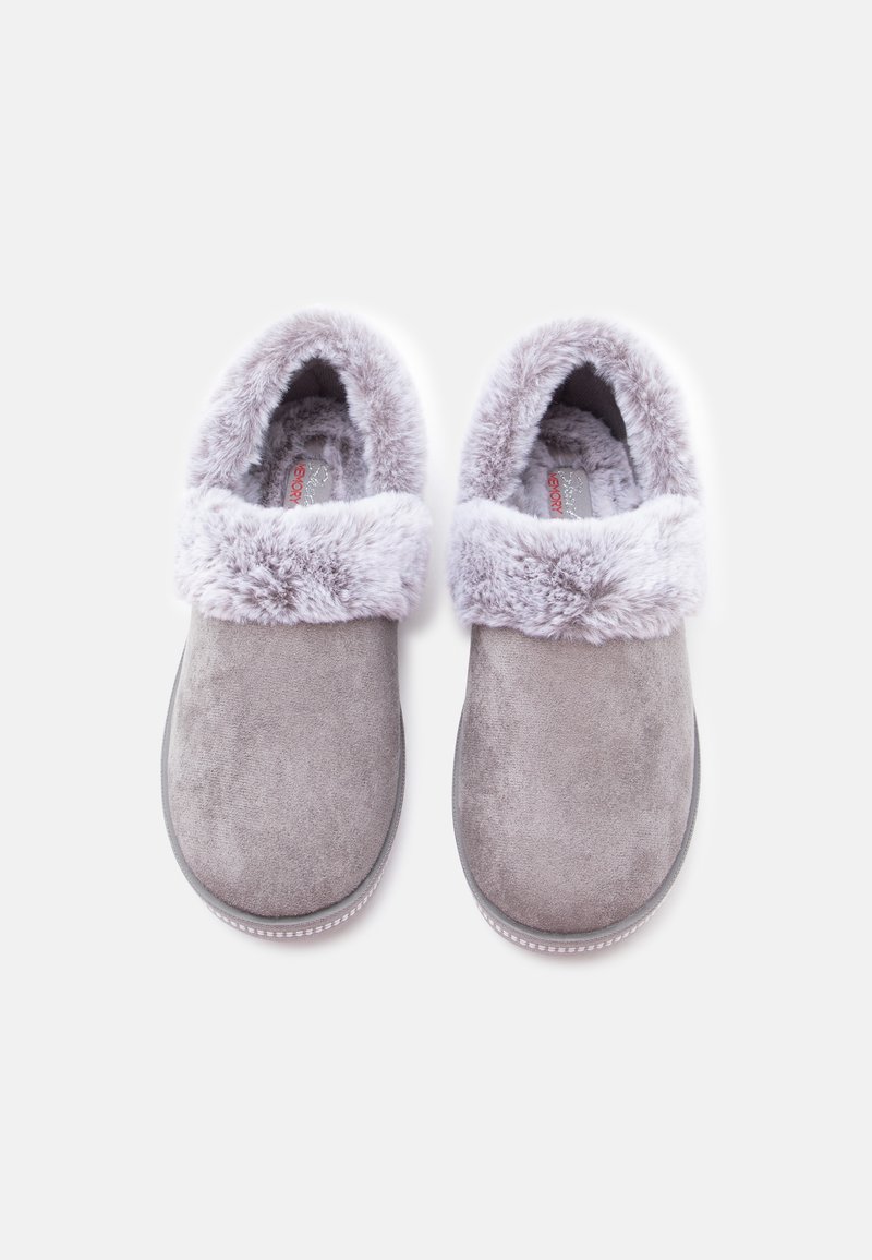 Zapatillas grises sin cordones con un suave puño de piel sintética, material parecido al ante, puntera redondeada y suela texturizada. El interior presenta un forro de felpa.