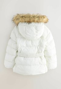 Baltas pūkains džemperis ar izšūtu apmali, elastīgu jostasvietu un kubiska struktūra. Iespējas ietver pieguļošu pielāgojumu un mīkstu, izolējošu materiālu.