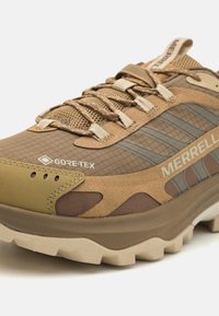 Light brown hiking shoe with mesh and suede materials, Gore-Tex branding, textured sole, and contrasting darker brown accents.