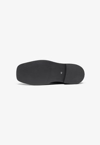 Suela de zapato negra con una superficie texturada y bordes redondeados. Talla 45 marcada en la suela. Perfil plano diseñado para la estabilidad.