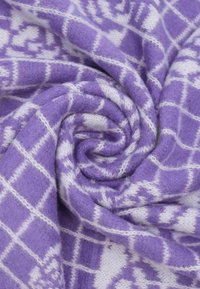 Tessuto a motivo viola arrotolato a spirale, caratterizzato da una consistenza morbida con disegni geometrici bianchi e un motivo a quadri.