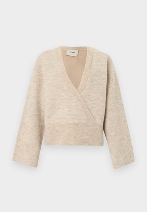 Beige strikket omslagsstil avkortet genser med lange ermer og bred ribbestrikket midje, merket "Aeron" på innsiden av nakken.