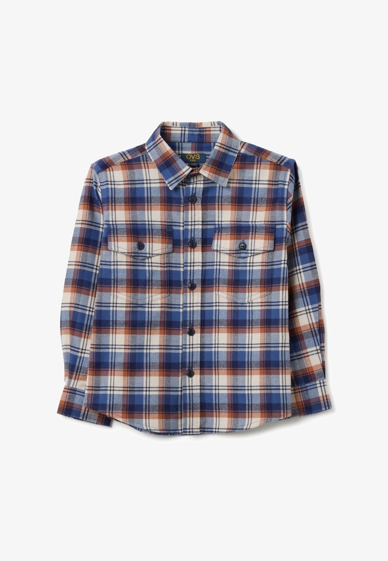 Camicia a quadri nei toni del blu, marrone e crema. Presenta una chiusura con bottoni, due tasche sul petto con bottoni neri e un colletto strutturato.