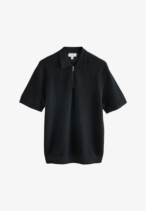 Svart kortärmad pikétröja med ett strukturerat tyg, som har en halv dragkedja framtill och en slät krage. Minimalistisk design med ribbstickade detaljer.