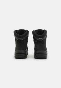 Schwarze High-Top-Stiefel mit einem strukturierten Stoff-Obermaterial, gepolstertem Kragen und glatter Gummisohle. Markenlogo auf der Rückseite und kontrastierendes Netzfutter.