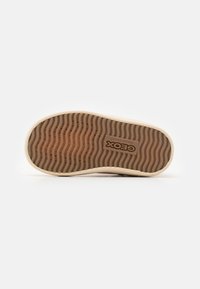 Geox-Sneaker-Sohle in Beige mit einem gerippten braunen Muster. Verfügt über ein geprägtes Logo und eine strukturierte Oberfläche für besseren Halt.