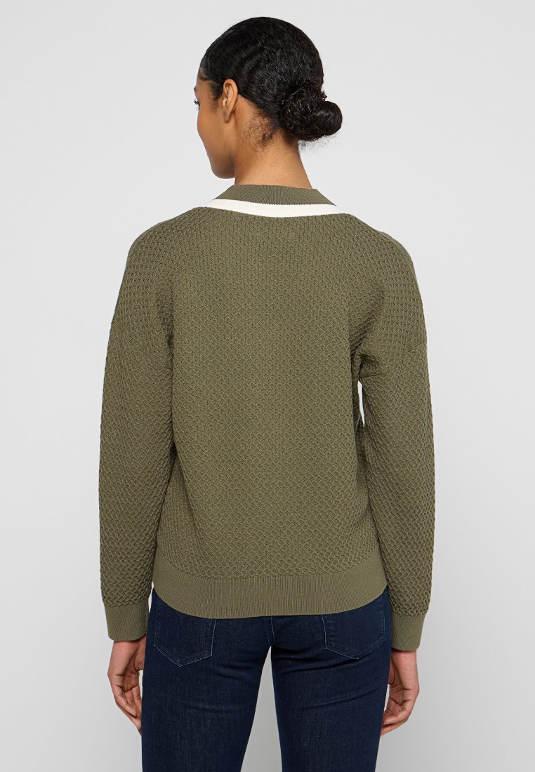 Pull en tricot vert avec un motif texturé, doté d'un col et de poignets en côtes blancs, et d'une coupe décontractée. Vue arrière affichée.