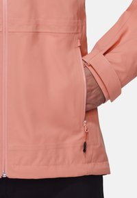 Helle rosa wasserdichte Jacke mit einem Frontreißverschluss und verstellbaren Manschetten. Sie verfügt über eine seitliche Tasche mit passendem Reißverschluss und Kordelzug.